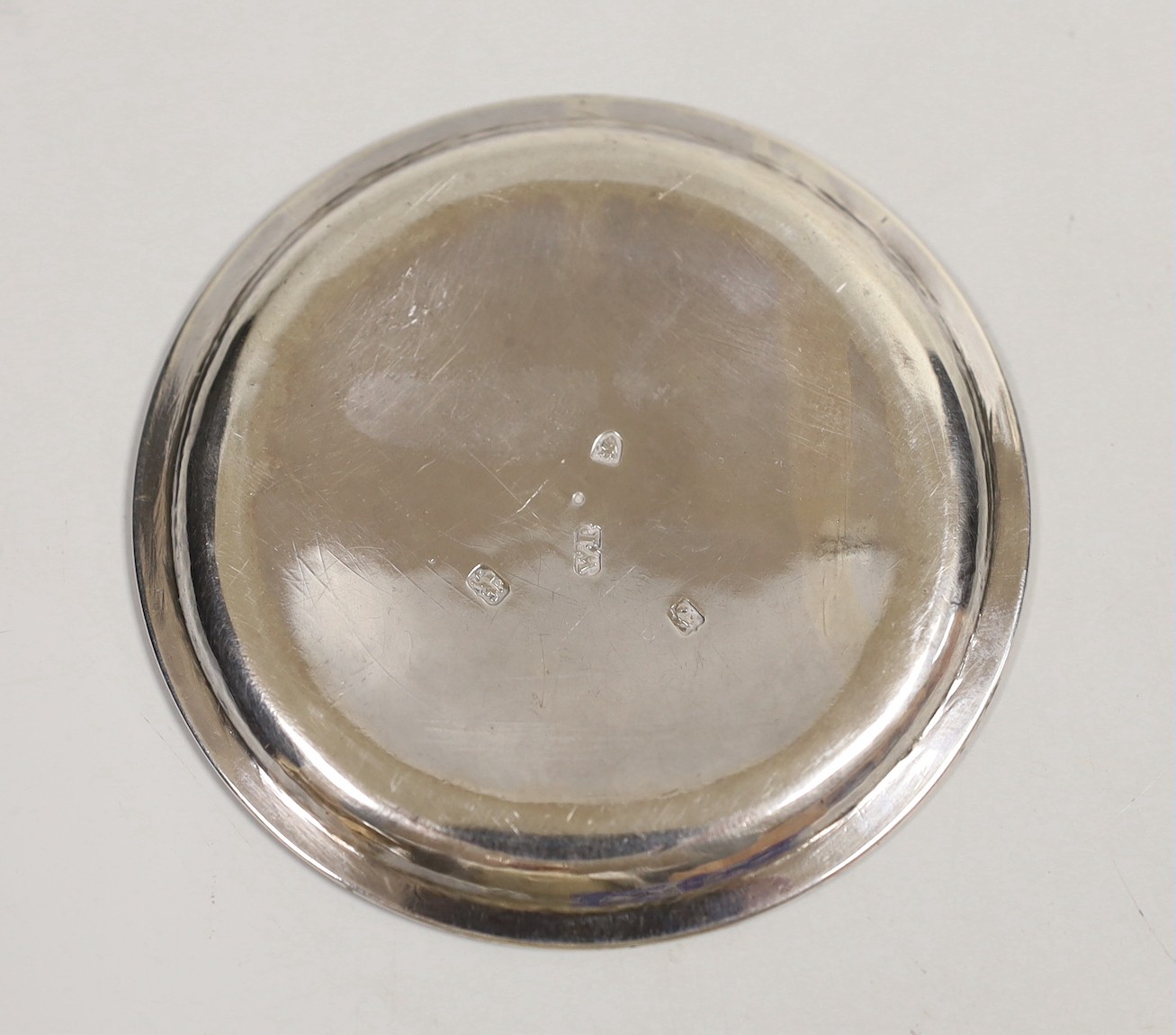 A George III silver glass coaster, William Plummer, London, 1781, 91mm, together with a pair of early 19th century Irish silver condiment spoons and a white metal cartouche.